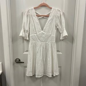 Mid-length sleeved deep V white dress. Detailed trim and openback